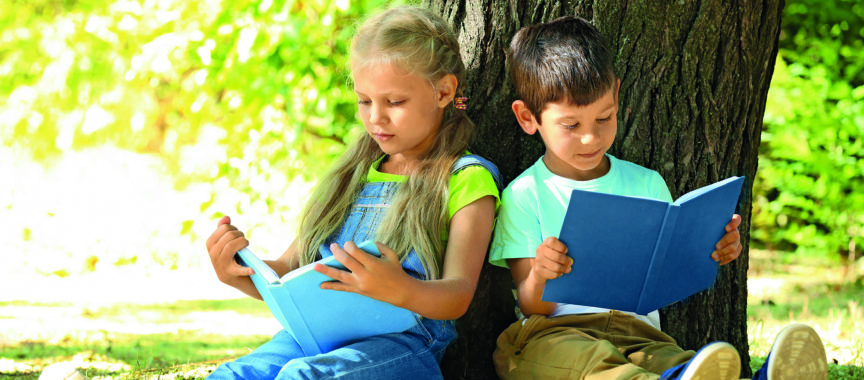 Lesende Kinder vor einem Baum