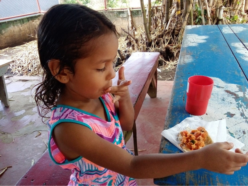 Kind isst seine Schulmahlzeit in Nicaragua