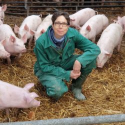 Ulrike SchreUlrike Schreiber umgeben von schweinischen Glücksbringern auf dem Bio-Gut Wulksfelde