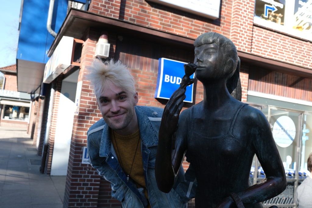 Jendrik Sigwart mit der bronzenen Eliza Doolittle in der Claus-Ferck-Straße. In „My fair Lady“ stand der vielseitige Künstler auch schon auf der Musical-Bühne.