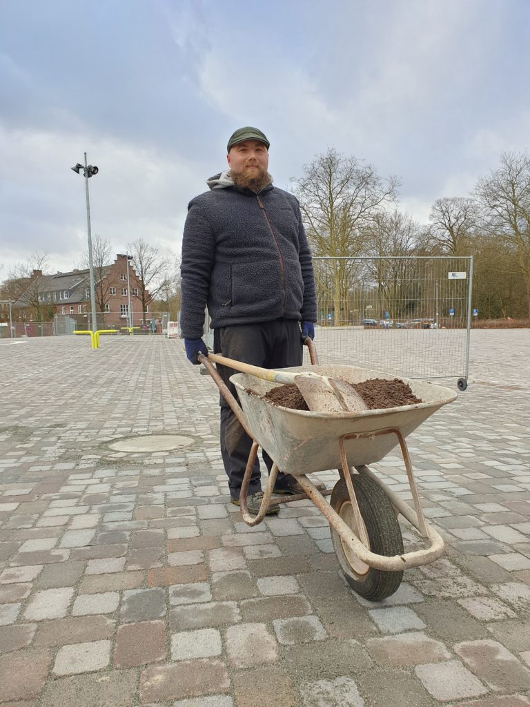 Mann mit Schubkarre auf dem Volksdorfer Marktplatz