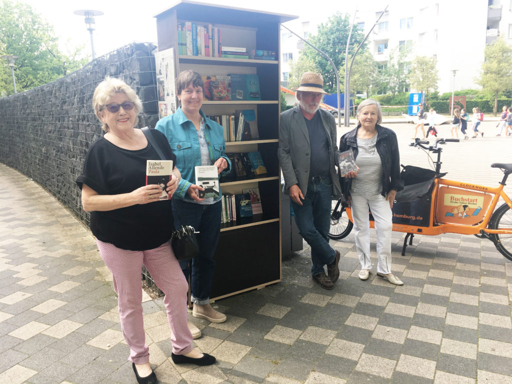 Beate Axt, Hilke Bleeken, Jürgen Kruse und Nachbarin Renate Köppe freuen sich über den neuen „Büchertauschturm“ am Norbert-Schmid-Platz.